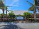 Landscaped entrance sign for Sunset Bar & Grill with palm trees and colorful flowers on a sunny day at 3230 Mangrove Point Dr, Ruskin, FL 33570