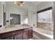 Bathroom features a double vanity, a soaking tub with tiled surround, and a large mirror at 4127 Moreland Dr, Valrico, FL 33596