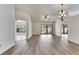 Open-concept living and dining area with wood-look flooring and a modern chandelier at 4127 Moreland Dr, Valrico, FL 33596