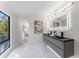 Sleek bathroom with a double vanity, a lighted mirror, and marble floors at 4520 Pine Hollow Dr, Tampa, FL 33624