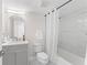 Bright bathroom with a shower-tub combo, white marble tile, and a gray vanity with gold accents at 4520 Pine Hollow Dr, Tampa, FL 33624