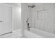 Bathroom featuring a modern bathtub, shower with rainfall shower head, and stylish white and marble tile at 4520 Pine Hollow Dr, Tampa, FL 33624