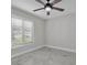 Bedroom with a modern ceiling fan, large window with blinds, and stylish, light-colored, marble-look tile flooring at 4520 Pine Hollow Dr, Tampa, FL 33624