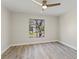 Bedroom with a ceiling fan and a window providing natural light and views of the outdoors, showcasing wood-look flooring at 4520 Pine Hollow Dr, Tampa, FL 33624