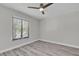 Bedroom with a ceiling fan, a window providing natural light and views of the outdoors, showcasing wood-look flooring at 4520 Pine Hollow Dr, Tampa, FL 33624