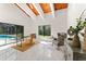 Bright living room featuring high ceilings, wood accents, and large windows with a view of the screened pool at 4520 Pine Hollow Dr, Tampa, FL 33624