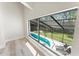 Bright window view of the screened-in pool area, with lounge chairs ready for relaxation at 4520 Pine Hollow Dr, Tampa, FL 33624