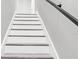 Bright staircase featuring white risers and grey wood-look treads, complemented by a sleek black handrail at 4520 Pine Hollow Dr, Tampa, FL 33624