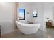 Elegant bathroom featuring a freestanding soaking tub next to a large window, offering a serene and relaxing atmosphere at 521 Baywood S Dr, Dunedin, FL 34698