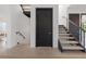 Hallway featuring a black door and staircase with stainless steel railing at 521 Baywood S Dr, Dunedin, FL 34698