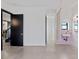 Bright hallway with concrete floors, and a powder room separated by an ornate curtain at 521 Baywood S Dr, Dunedin, FL 34698