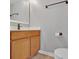 Well-lit half bathroom featuring a wooden vanity and modern fixtures at 5337 Treig Ln, Wesley Chapel, FL 33545