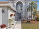 Home's entrance with a decorative front door, complemented by a manicured garden and stone pathway at 5337 Treig Ln, Wesley Chapel, FL 33545