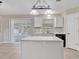 Spacious kitchen with an island, white cabinets, tile floor, and a sliding door to the backyard at 5337 Treig Ln, Wesley Chapel, FL 33545