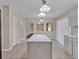 Kitchen features white island, white cabinets, neutral walls, and an arched doorway at 5337 Treig Ln, Wesley Chapel, FL 33545