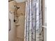 Tiled shower with mosaic accents, shower head, and grab bar at 5337 Treig Ln, Wesley Chapel, FL 33545