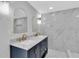 Modern bathroom with double vanity, gold fixtures, and stylish white marble tiling at 5440 Quist Dr, Port Richey, FL 34668