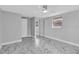 Light and bright empty bedroom with white marble floors, light grey paint, and a ceiling fan at 5440 Quist Dr, Port Richey, FL 34668