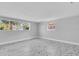 Light and bright empty bedroom with white marble floors, light grey paint, and two windows for ample light at 5440 Quist Dr, Port Richey, FL 34668