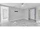 Light and bright empty bedroom with white marble floors, light grey paint, and a ceiling fan at 5440 Quist Dr, Port Richey, FL 34668