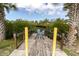 The wooden dock overlooks a tranquil waterway lined with lush mangrove trees and clear blue skies at 5440 Quist Dr, Port Richey, FL 34668