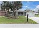 Charming single-story home featuring a well-maintained lawn, mature palms, and an attached one-car garage at 5440 Quist Dr, Port Richey, FL 34668