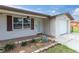 Charming home with a brick accented porch, a well-manicured lawn, and attached single car garage at 5440 Quist Dr, Port Richey, FL 34668