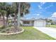This charming single-story home boasts a lush, green lawn, mature trees, and an attached garage at 5440 Quist Dr, Port Richey, FL 34668