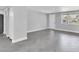 Large living room with herringbone tile flooring, a window, a door, and neutral paint at 5440 Quist Dr, Port Richey, FL 34668
