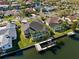 Waterfront home featuring a private boat dock and lift with an enclosed pool area surrounded by palm trees at 5815 Dory Way, Tampa, FL 33615