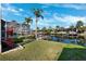 Backyard featuring lush green grass, manicured landscaping, and a screened-in patio and canal view at 5815 Dory Way, Tampa, FL 33615