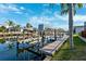 A waterfront dock equipped with a boat lift provides convenient access to the water, surrounded by lush landscaping at 5815 Dory Way, Tampa, FL 33615