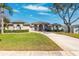 Inviting home showcasing a manicured lawn, an expansive driveway, and an attached two-car garage at 5815 Dory Way, Tampa, FL 33615