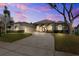 Charming stucco home showcasing lush landscaping, a circular driveway, and an attached two-car garage at 5815 Dory Way, Tampa, FL 33615