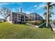 Home exterior with an expansive screened-in patio, well-maintained landscaping, and tranquil waterfront views at 5815 Dory Way, Tampa, FL 33615
