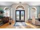Inviting foyer showcasing a decorative front door, transom windows, and elegant hardwood flooring at 5815 Dory Way, Tampa, FL 33615