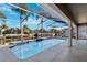 Screened-in pool area with waterfront views and tropical landscaping at 5815 Dory Way, Tampa, FL 33615