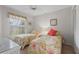 Bright bedroom featuring twin beds with floral bedding, a ceiling fan, and natural light from the window at 6077 Bahia Del Mar Blvd # 119, St Petersburg, FL 33715