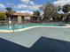 Community pool with lounge chairs and shade trees under a sunny sky at 6308 Newtown Cir # 8A3, Tampa, FL 33615