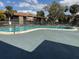 Community pool with lounge chairs and shade trees under a sunny sky at 6308 Newtown Cir # 8A3, Tampa, FL 33615