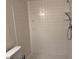 Bright shower features tiled walls, updated fixtures, and shelving at 6308 Newtown Cir # 8A3, Tampa, FL 33615