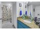 Bathroom featuring granite counters, a vanity, storage, and nautical themed shower curtain at 6311 93Rd N Ter # 4403, Pinellas Park, FL 33782