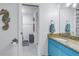 Bathroom with blue vanity, granite countertop, and open doorway to the shower and toilet at 6311 93Rd N Ter # 4403, Pinellas Park, FL 33782