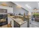 Kitchen with granite counters, sink, and view of the living area with vaulted ceilings and skylights at 6311 93Rd N Ter # 4403, Pinellas Park, FL 33782