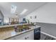 Bright kitchen featuring granite countertops, stainless steel sink, and dishwasher with views of living area at 6311 93Rd N Ter # 4403, Pinellas Park, FL 33782