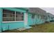 Charming exterior view of a turquoise single-story townhome with a gray roof and tidy front yard at 7060 Lafayette St # 7060, Pinellas Park, FL 33781