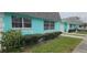 Exterior view of a tidy turquoise townhome with a tidy landscaped front yard and a white garage at 7060 Lafayette St # 7060, Pinellas Park, FL 33781