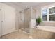 Beautiful bath featuring a walk-in shower and a separate soaking tub under a window with wooden slat blinds at 715 W Woodlawn Ave, Tampa, FL 33603