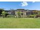 Expansive backyard with lush green grass, screened-in patio, and a beautiful home facade at 8005 Cypress Crossing Ct, Tampa, FL 33647