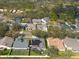 This aerial shot displays a neighborhood with mature trees, well-kept lawns, and a serene pond at 9415 Pebble Glen Ave, Tampa, FL 33647